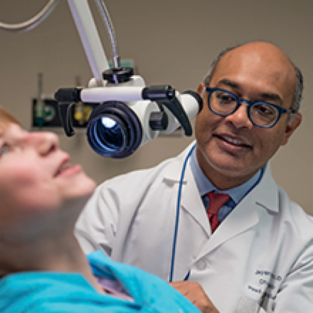 A doctor speaking to a patient; a medical device is visible
