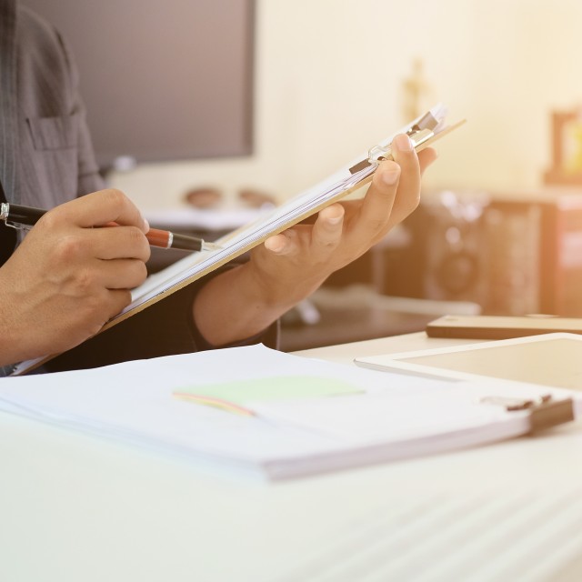 A person&#039;s hands holding a clipboard with a checklist
